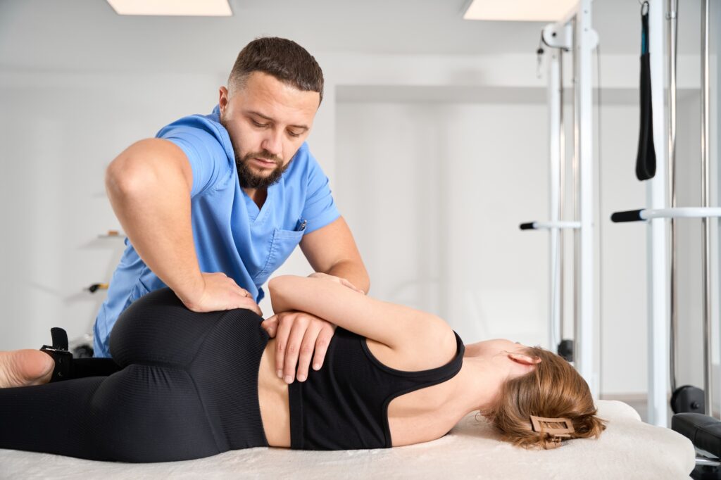 Chiropractor working on young woman spine