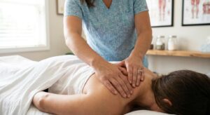 Acupuncturist examining patient's back muscles before needle insertion at chiropractic clinic